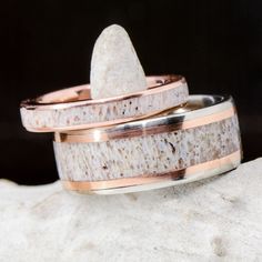 two wedding bands made out of antelope and copper with a rock in the middle