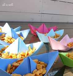 several paper boats filled with cereal on top of a table