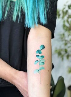 a woman with blue hair has a tattoo on her arm