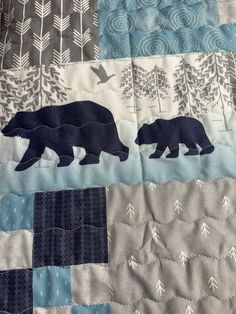 two bears are walking in the woods on this quilt