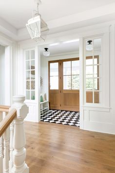 an empty room with wood floors and white walls, along with a black and white checkered floor