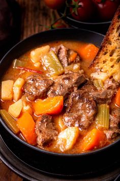 a close up of a bowl of food with meat and vegetables in it on a table