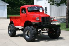 an old red truck parked in front of a house