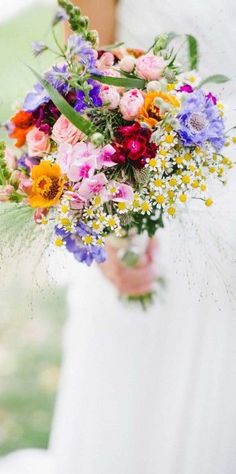 a woman holding a bouquet of flowers in her hand