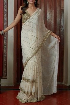 "Handmade Ivory Saree has hand embellishments like a mirror,  zardozi, aari and Zari. It is perfect for any occasion. It comes with a blouse stitched. Saree is custom-made. Once you will order I will send you a measurement sheet which you need to fill out. Alternatively, you could just choose an age group in which case I would use the standard measurement for that age. Please allow 1-2 weeks for the order to get processed and shipped as the dress is made with love just for you! And we make sure to make you wear the BEST Customers need to know all of the dresses don't come \"on the shelf\" we strongly recommend you to select \"custom made\"to ensure that the dress will fit you when it arrives. NOTE: All our items are handmade and specially customized for our beautiful customers. This is mad Georgette Saree Party Wear, Off White Saree, Mirror Work Saree, Saree Party Wear, Mirror Work Blouse, Bridesmaid Saree, Ruffle Saree, White Saree, Drape Saree