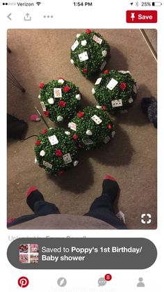 someone is sitting on the floor next to some christmas wreaths that have been made out of baby shower balls