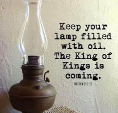 a lamp sitting on top of a table next to a wall with a bible quote