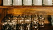 many glasses are lined up on a shelf