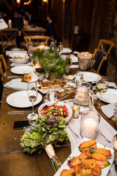 a long table is set with plates and candles