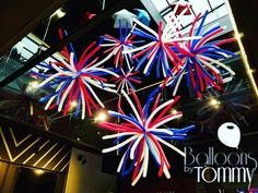 red, white and blue fireworks are hanging from the ceiling