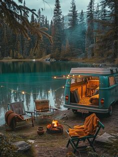 a camper van parked next to a lake at night with lights on the windows