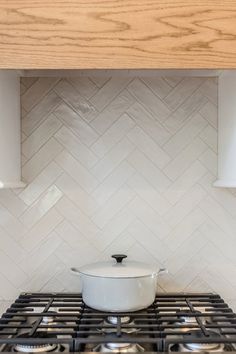 a stove top oven sitting under a wooden shelf