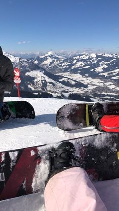 two snowboarders sitting on the top of a snowy mountain