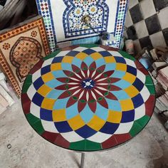 a table that is sitting on the ground in front of some tile designs and pictures