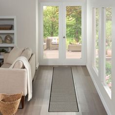 a living room filled with furniture and lots of glass doors leading to a patio area