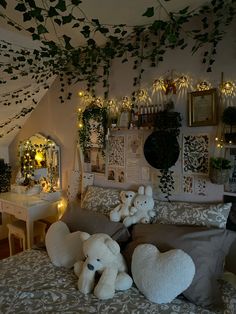 two teddy bears sitting on the bed in a bedroom decorated with greenery and lights