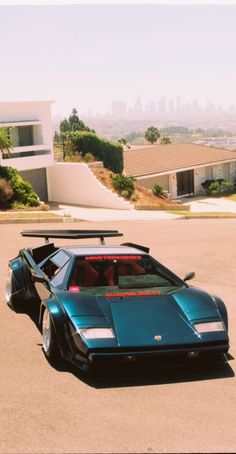 a blue sports car parked in front of a house