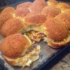 a pan filled with sandwiches sitting on top of a counter