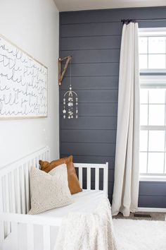 a white bed sitting in a bedroom next to a window