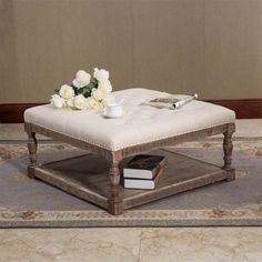 a coffee table with white flowers on it and a book in front of the top