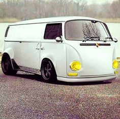 an old white van parked next to a body of water