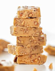 five pieces of peanut butter fudge are stacked on top of each other with nuts