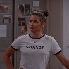 a woman standing in front of a refrigerator with her hands on her hips and looking at the camera