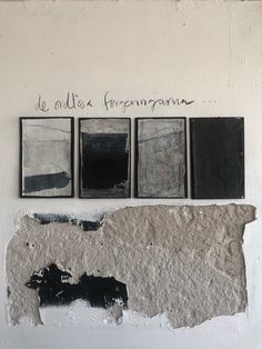 four black and white paintings hanging on the side of a wall next to each other