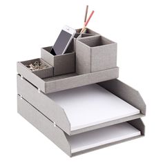 an open cardboard box with two drawers and a cell phone in it on top of some papers