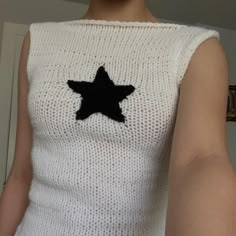 a woman wearing a white sweater with a black star on it