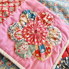 a close up of a patchwork quilt with flowers on it