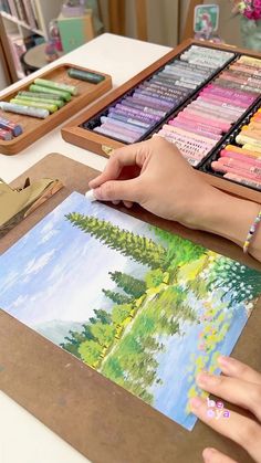 a woman is working on an art project with crayons and colored pencils