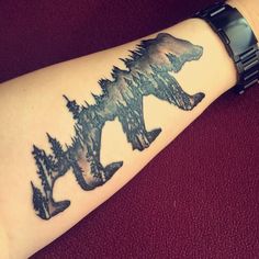 a bear and trees tattoo on the arm