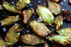 some kind of food that is sitting on a black surface with salt and pepper flakes