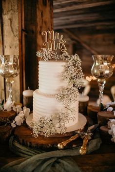 a white wedding cake sitting on top of a wooden table