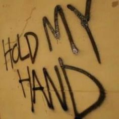 graffiti written on the side of a wall that says hold my hand with scissors in it