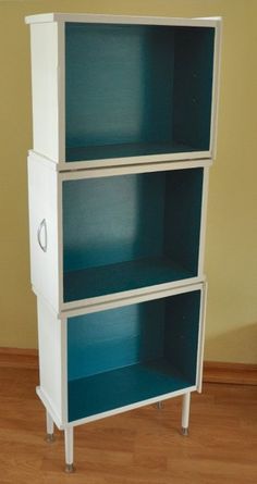 a white and blue bookcase sitting on top of a hard wood floor