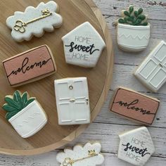 decorated cookies sitting on top of a wooden table next to a potted plant and door