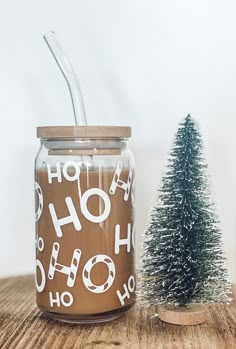 a small christmas tree next to a jar with the word ho hoo on it