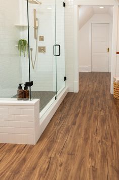 a bathroom with wood flooring and white walls