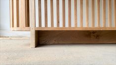 a wooden bed frame sitting on top of a carpeted floor next to a wall