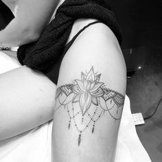 a woman's thigh with a tattoo design on the leg and an intricate flower