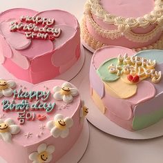 three heart shaped cakes with happy birthday written on them and hearts in the shape of flowers