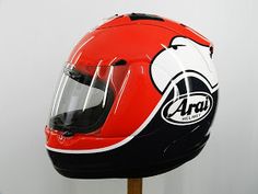 the helmet is red, black and white with an animal on it's side