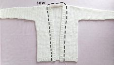 a white knitted sweater with black stitchs on the front and side, along with measurements