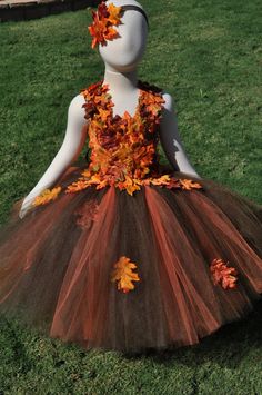 a mannequin dressed in an orange and brown tutu with leaves on it