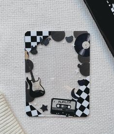 a black and white photo frame with an old fashioned record player on it next to a pair of scissors