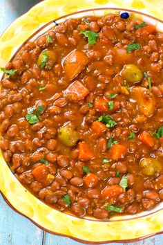 a yellow bowl filled with beans and vegetables