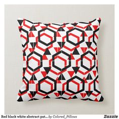 a black and white pillow with red geometric designs