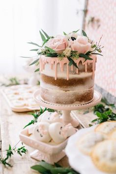 a cake sitting on top of a table covered in frosted icing and flowers